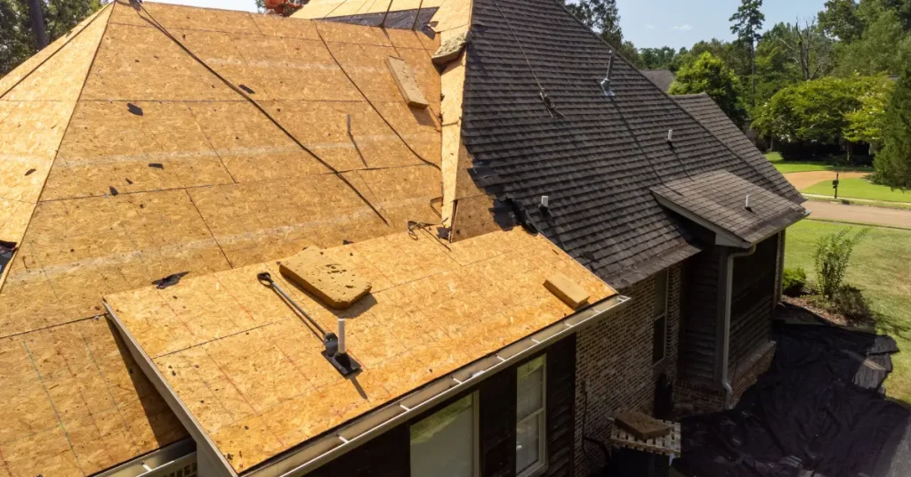 Roof replacement in progress with half of the roof's shingles and underlayment torn off.